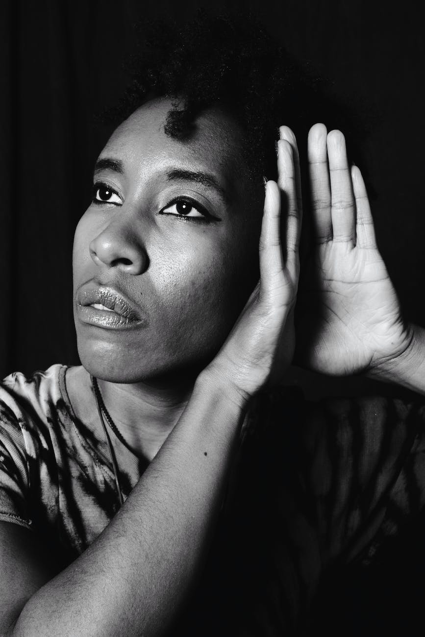 a grayscale photo of a woman in hearing position of her hands