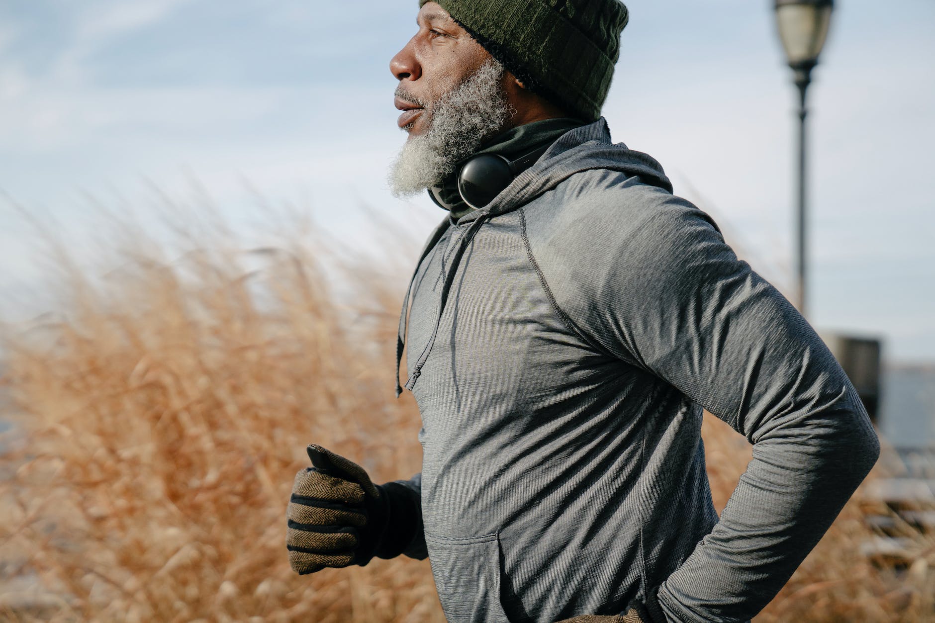 black man in sportswear jogging in sunny autumn day